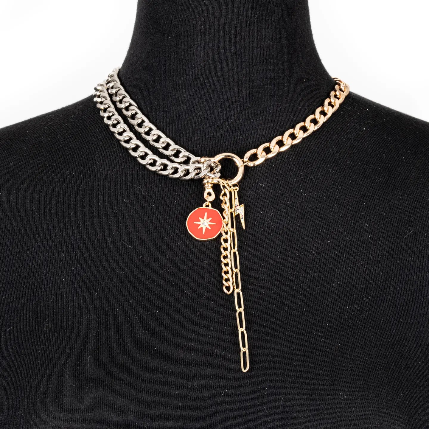 Mixed metal chain necklace with red charm and drop chain in gold and silver tones on white background.