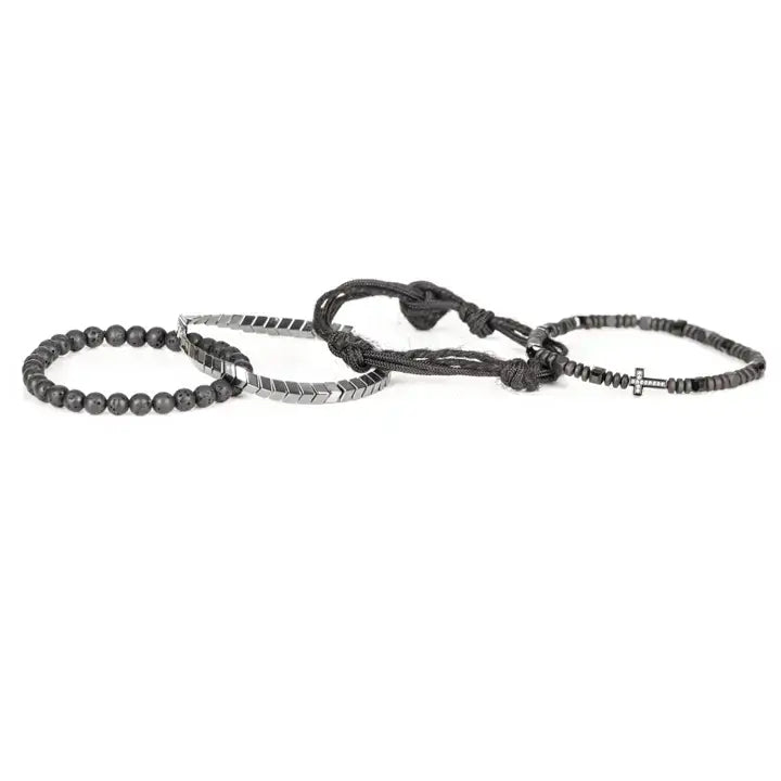 Black layered men’s bracelet set with lava stone beads, pavé cross detail, silver chevron metal strand, braided rope wraps, and woven texture accents on white background.