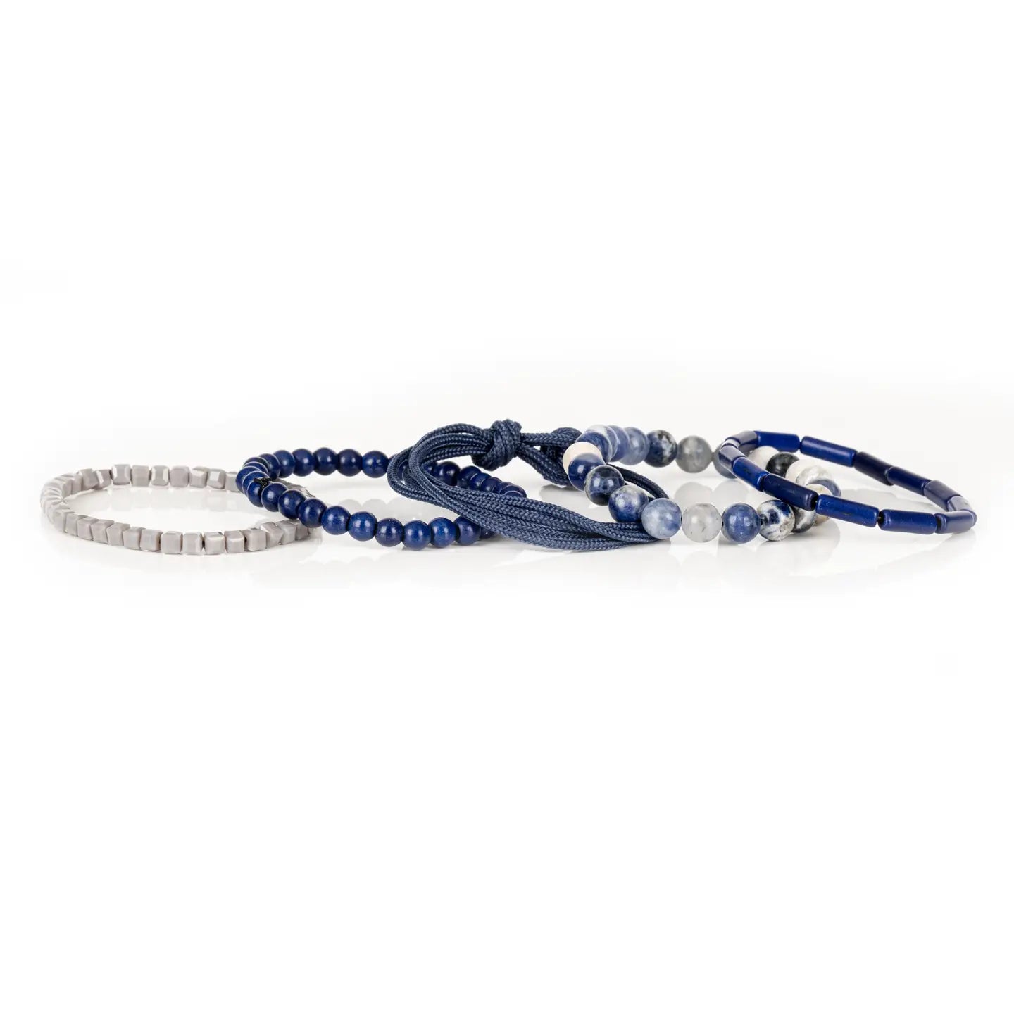 Men’s layered bracelet set featuring deep blue lapis-style beads, blue and white marbled natural stone beads, navy braided cord wraps, matte blue round beads, and light gray geometric heishi beads, stacked in a sophisticated nautical-inspired luxury design on a white background.