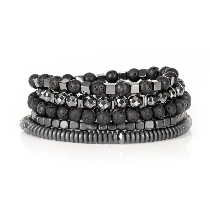 Black multi-layer men’s bracelet set featuring lava stone beads, faceted hematite stones, metallic cube accents, and layered gunmetal bead strands on a light background.