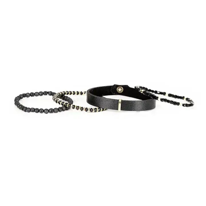 Men’s layered bracelet set featuring a black textured leather cuff, faceted black crystal beads, matte black lava stone beads, metallic hematite accents, and gold-tone spacer details, stacked in a refined black and gold luxury design on a white background.