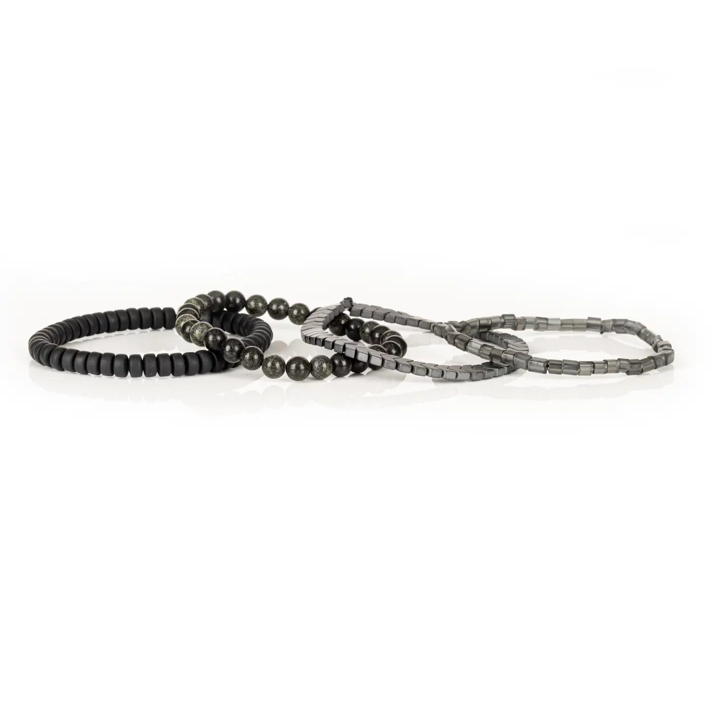 Men’s layered bracelet set featuring gunmetal chevron metal beads, smoky gray translucent beads, black matte heishi beads, and dark gray natural stone beads with subtle metallic shimmer, stacked in a sophisticated monochromatic luxury design on a white background.
