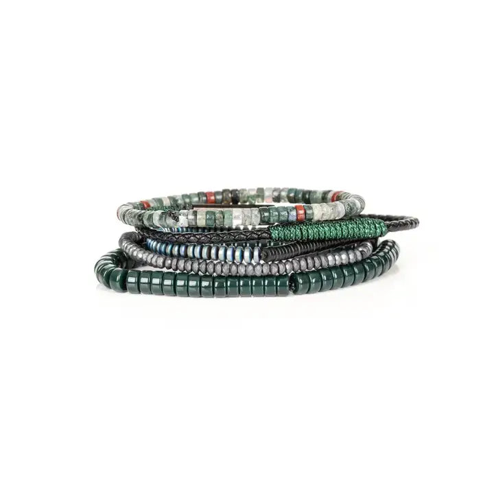 Men’s layered bracelet set featuring dark green heishi beads, green woven cord, black braided leather, hematite spacer beads, and green-gray natural stone beads with subtle red accents, stacked in a sophisticated earthy luxury design on a white background.