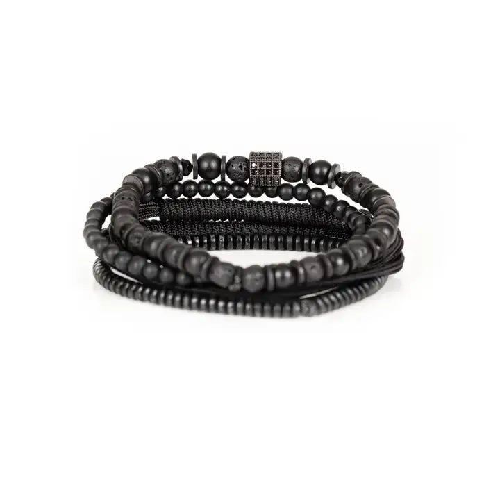 Black layered men’s bracelet set with matte black beads, lava stone accents, braided rope wraps, and dark pavé square detail on white background.