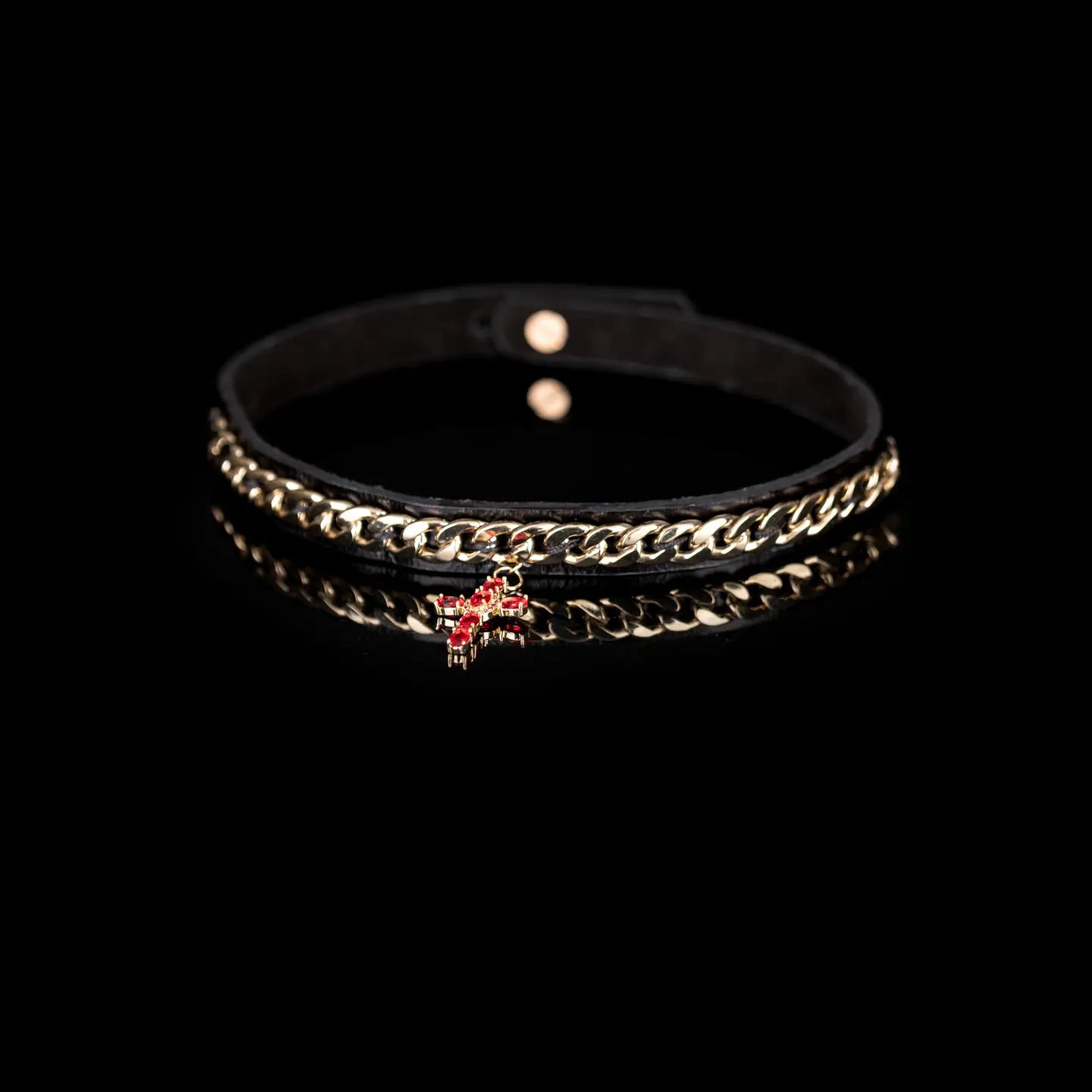 Black leather choker with gold chain detail and a red crystal cross pendant, centered on a white background.