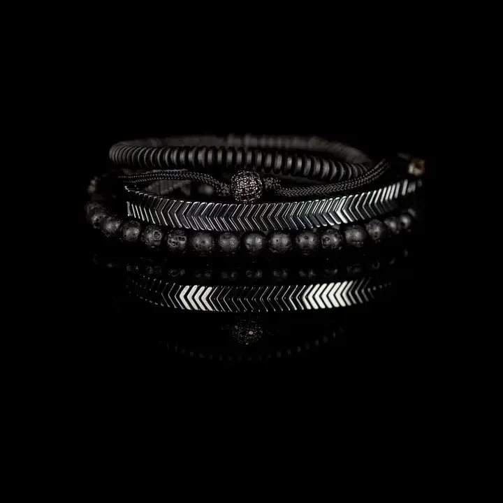 Black and silver layered men’s bracelet set with lava stone beads, silver chevron metal bar, matte black spacer beads, and pavé centerpiece on white background.