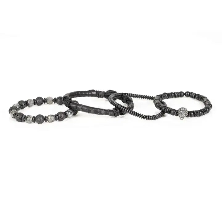 Black multi-layer men’s bracelet featuring crystal skull centerpiece, lava stone beads, marble grey natural stones, wrapped leather layer, and matte black bead strands on a light background.
