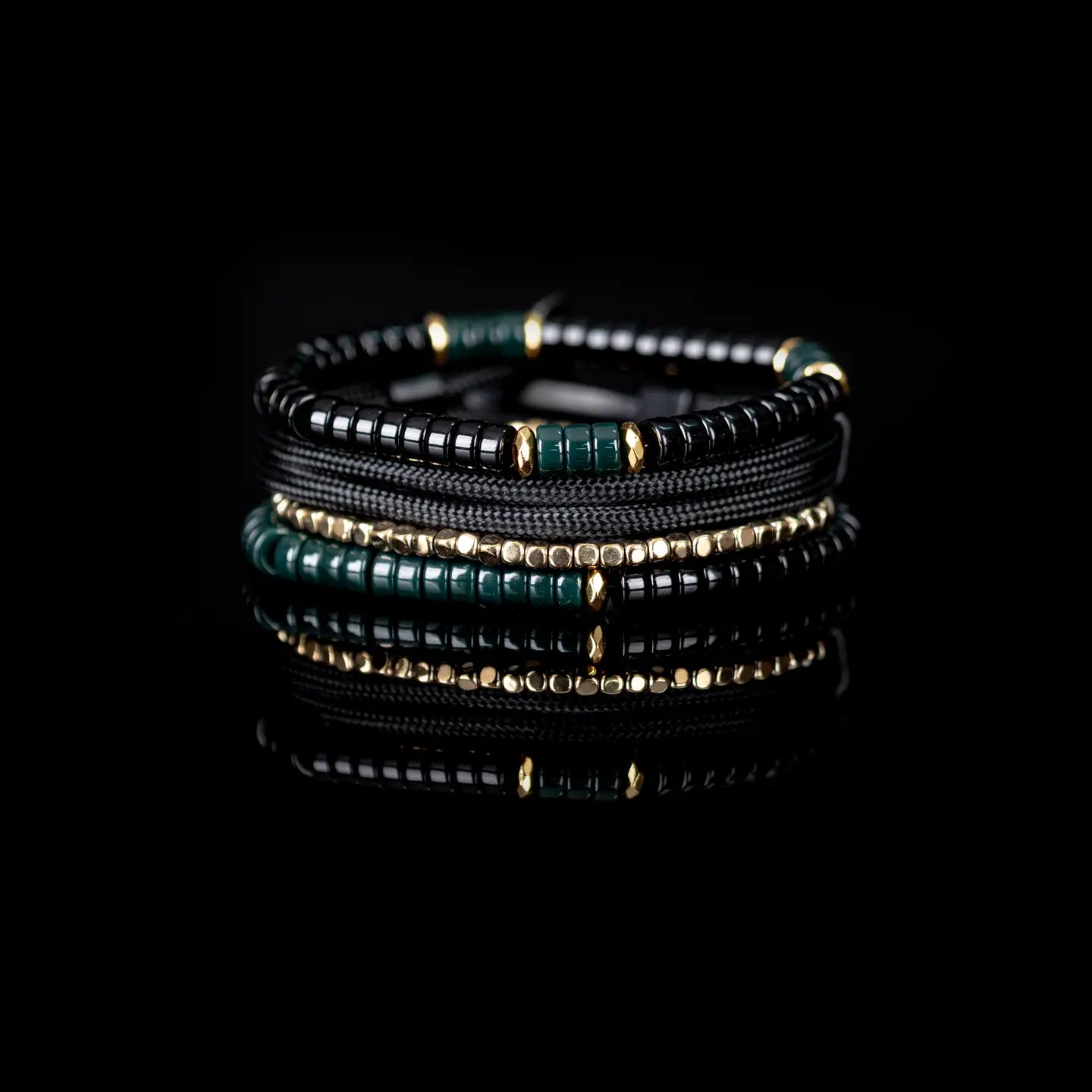 Men’s layered bracelet set featuring black and deep green heishi beads, black braided cord wraps, gold-tone spacer beads, and polished black accent beads, stacked in a sophisticated green, black, and gold luxury design on a white background.