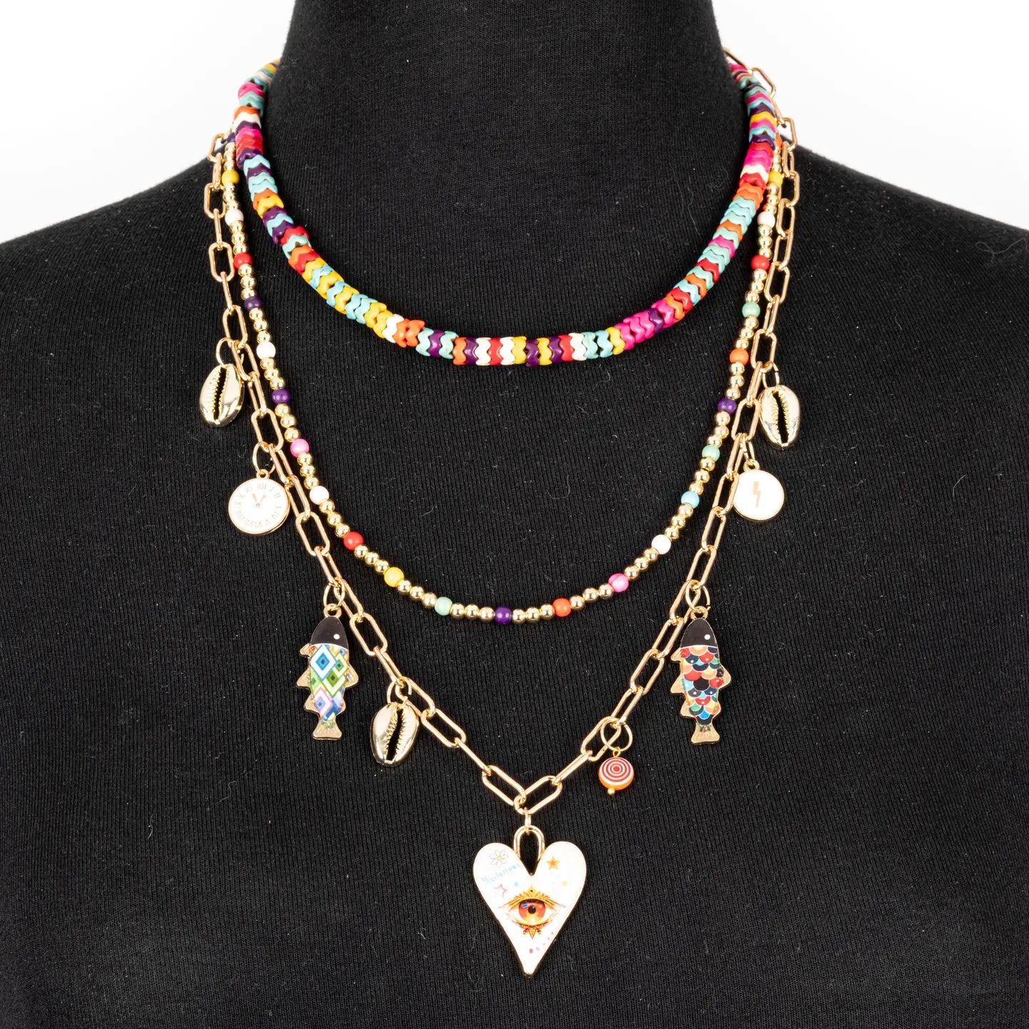 Colorful layered necklace with multicolor beads, gold chains and evil eye heart pendant on white background.