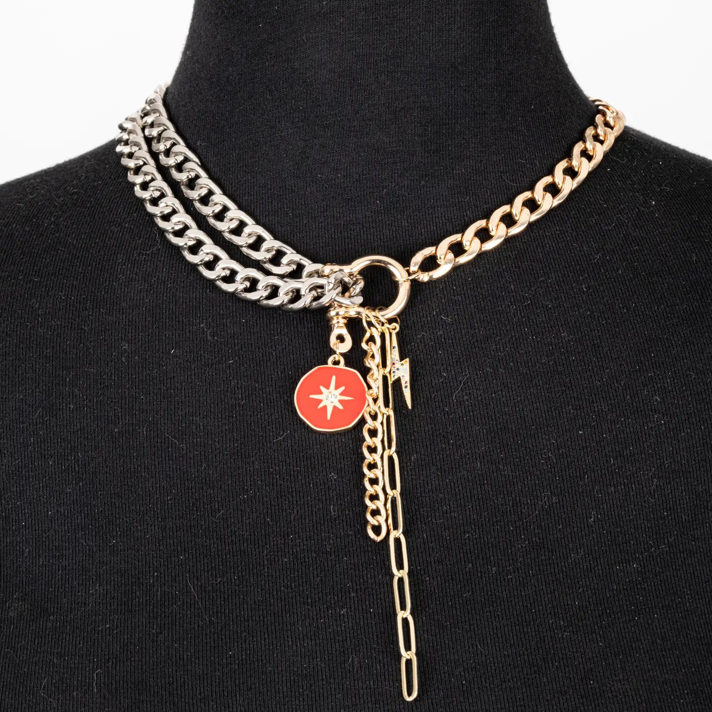 Mixed metal chain necklace with red charm and drop chain in gold and silver tones on white background.