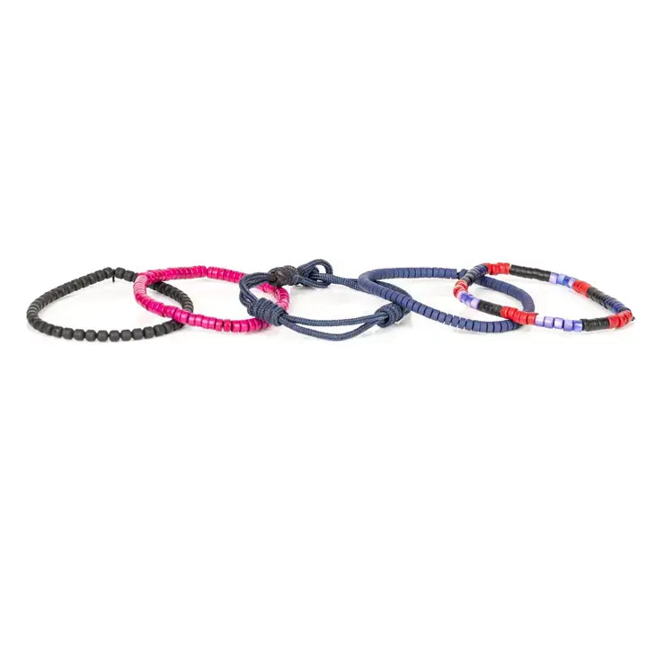 Men’s layered bracelet set featuring navy blue braided cord, blue, black, red, and fuchsia heishi beads, black cube beads, and marbled blue accent beads, stacked in a vibrant contemporary luxury design on a white background.