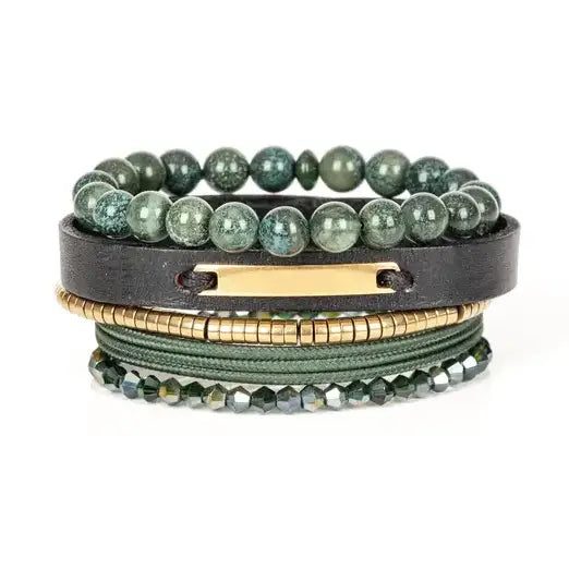 Men’s layered bracelet set featuring green natural stone beads, a black leather cuff with a gold-tone ID plate, olive braided cord wraps, gold-tone heishi beads, and faceted green crystal beads, stacked in a refined earthy luxury design on a white background.