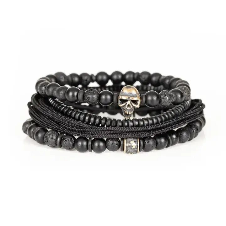 Black layered men’s bracelet set with matte beads, lava stone accents, braided rope wraps, and metallic skull centerpiece on white background.