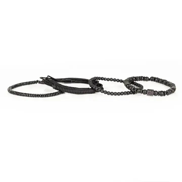 Black layered men’s bracelet set with matte black beads, lava stone accents, braided rope wraps, and dark pavé square detail on white background.