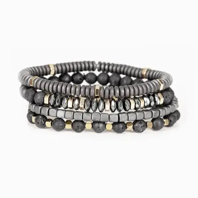 Men’s layered bracelet set featuring matte black lava stone beads, gray heishi beads, silver-tone hematite cube beads, faceted hematite crystal beads, and gold-tone spacer accents, stacked in a sophisticated industrial luxury design on a white background.