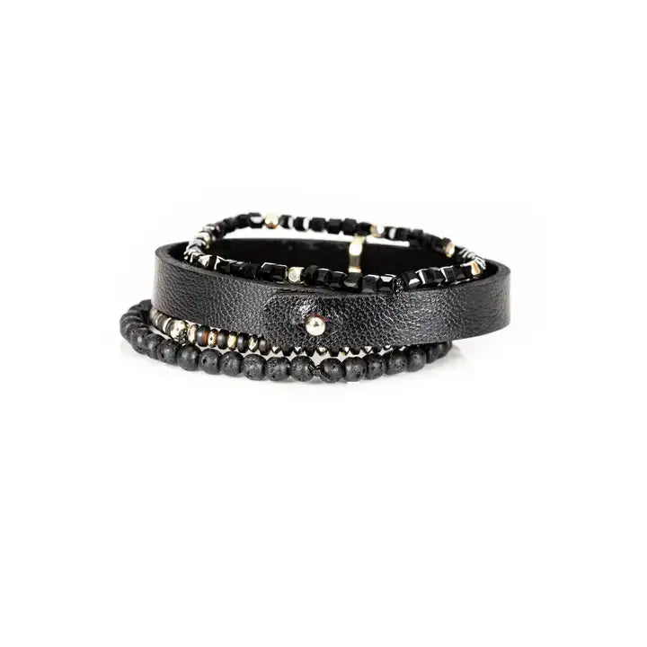 Men’s layered bracelet set featuring a black textured leather cuff, faceted black crystal beads, matte black lava stone beads, metallic hematite accents, and gold-tone spacer details, stacked in a refined black and gold luxury design on a white background.
