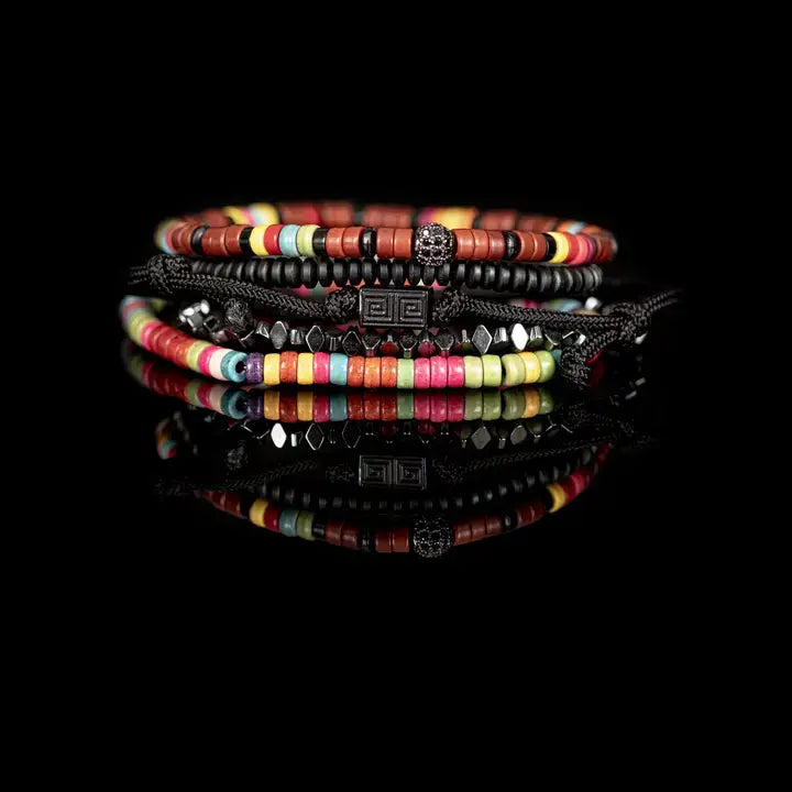 Multicolor multi-layer men’s bracelet featuring colorful disc bead strands, faceted hematite accents, braided black rope layers, and black geometric centerpiece on a light background.