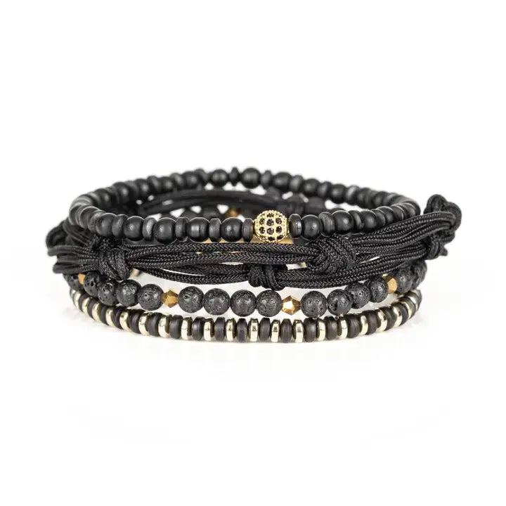 Black and gold layered men’s bracelet set with matte black beads, lava stone accents, gold pavé centerpiece bead, metallic spacers, and braided rope wraps on white background.