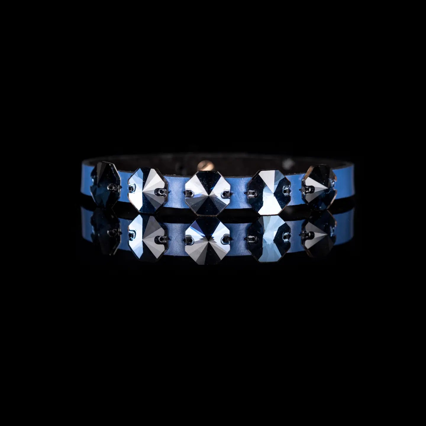 Black leather choker with a row of dark geometric faceted crystals across the front, displayed on a white background.