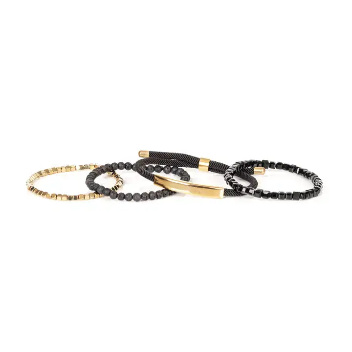 Men’s layered bracelet set featuring faceted black crystal beads, matte black lava stone beads, black braided cord, a polished gold-tone bar centerpiece, and gold-tone hematite-style spacer beads, stacked in a sophisticated black and gold luxury design on a white background.
