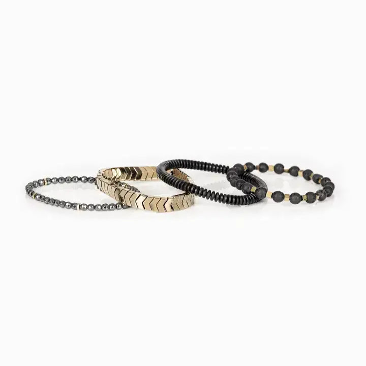 Men’s layered bracelet set featuring gold-tone chevron metal beads, matte black lava stone beads with gold-tone spacers, black heishi beads, and faceted hematite crystal beads, stacked in a sophisticated black and gold luxury design on a white background.