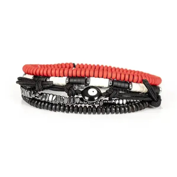 Men’s layered bracelet set featuring coral-red heishi beads, black braided cord wraps, black and white accent beads, faceted hematite crystal beads, black heishi beads, and an evil eye centerpiece, stacked in a bold contemporary bohemian luxury design on a white background.