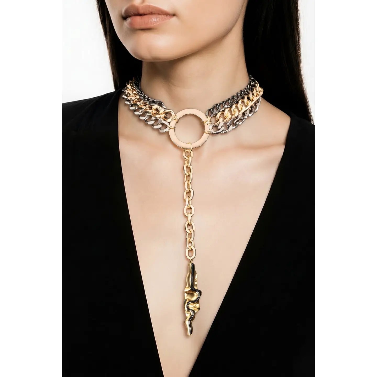 Mixed metal chain necklace with central ring and long drop pendant in gold and gunmetal tones on white background.