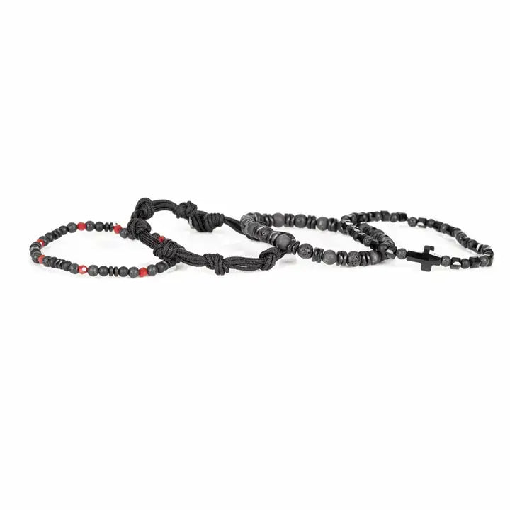 Black multi-layer men’s bracelet set featuring lava stone beads, faceted black onyx, braided rope bands, black cross centerpiece, and subtle red accent beads on a light background.