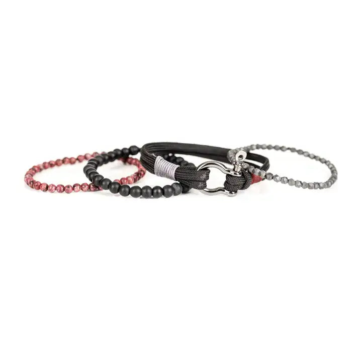 Black and red multi-layer men’s bracelet featuring metallic hook clasp, braided black rope, faceted hematite crystals, matte black beads, and red marbled natural stone beads on a light background.