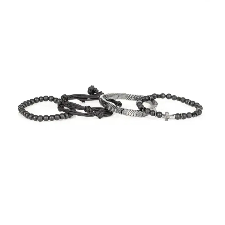 Black and silver layered men’s bracelet set with matte black beads, silver chevron metal bar, pavé cross detail, and braided rope wraps on white background.