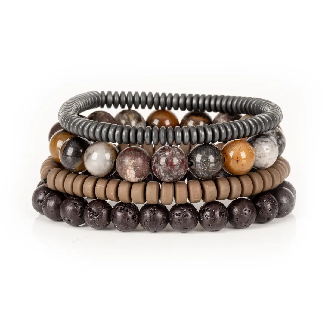 Men’s layered bracelet set featuring dark lava stone beads, multicolor natural stone beads in earthy brown, gray, cream, and rust tones, taupe heishi beads, and gunmetal coil wrap beads, stacked in a rugged natural luxury design on a white background.