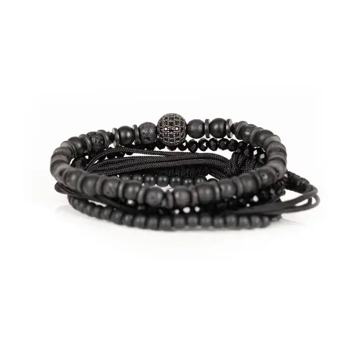 Black layered men’s bracelet set with matte black beads, faceted crystal accents, braided rope wraps, and pavé centerpiece bead on white background.