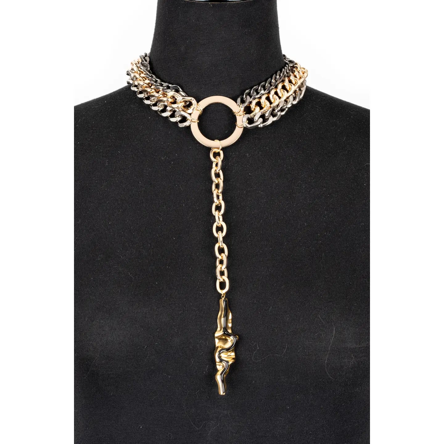 Mixed metal chain necklace with central ring and long drop pendant in gold and gunmetal tones on white background.