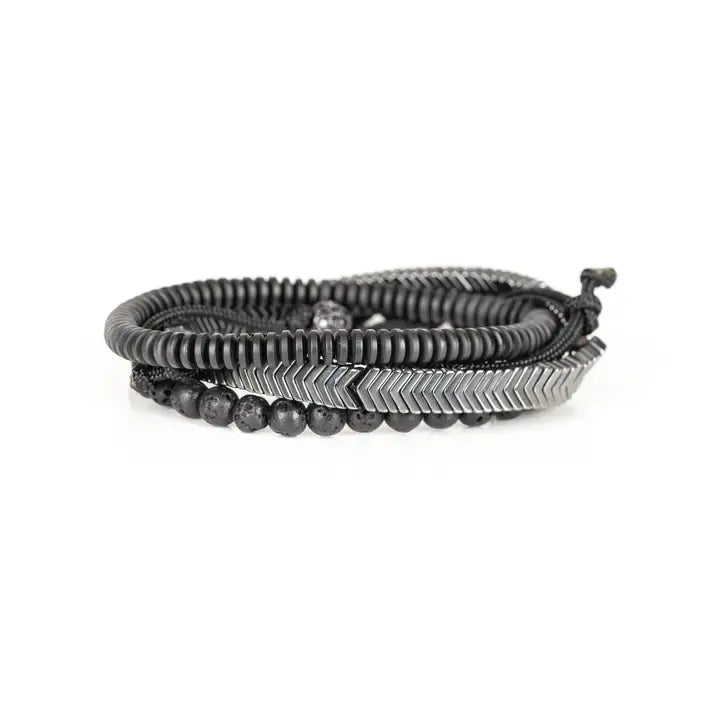 Black and silver layered men’s bracelet set with lava stone beads, silver chevron metal bar, matte black spacer beads, and pavé centerpiece on white background.