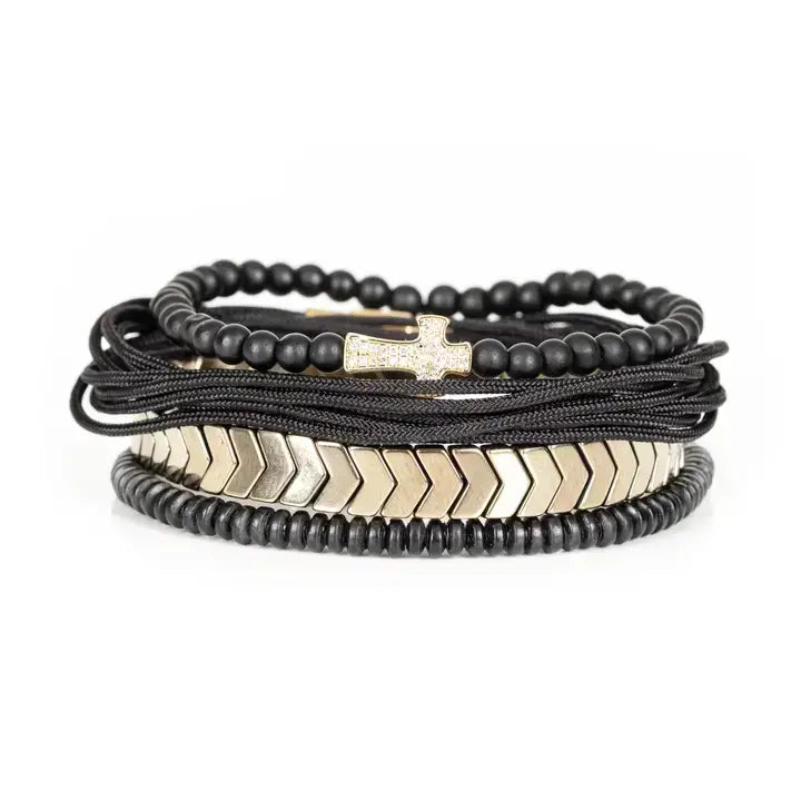 Black multi-layer men’s bracelet set featuring matte onyx beads, braided black rope, crystal cross centerpiece, gold chevron metal bar, and layered metallic accents on a light background.