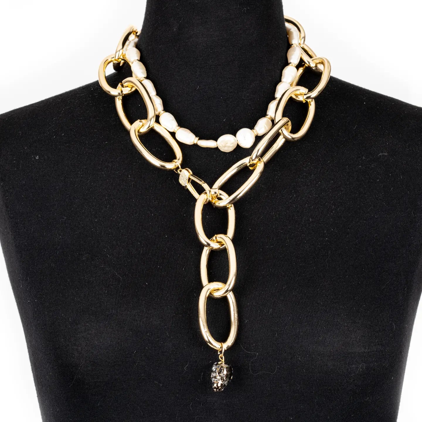 Gold oversized chain necklace with pearl accent and crystal drop pendant on white background.
