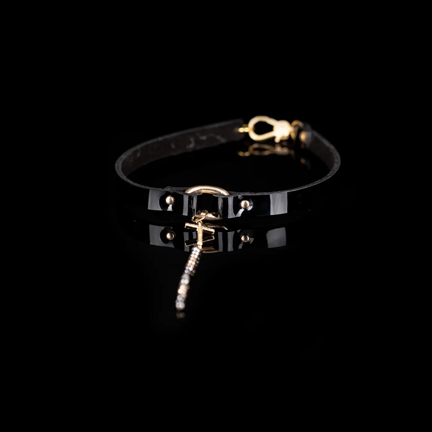 Black leather choker with a gold cross pendant and a long beaded chain drop, displayed on a white background.