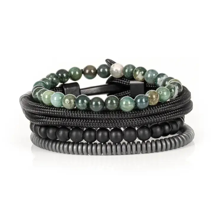 Green and black multi-layer men’s bracelet featuring natural green stone beads, braided black rope layers, matte black onyx beads, and gunmetal hematite disc strands on a light background.