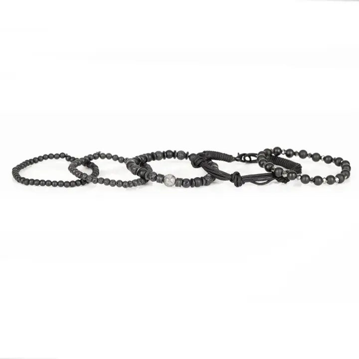 Black layered men’s bracelet set with matte black beads, lava stone accents, marbled centerpiece stone, faceted metallic beads, and braided rope wraps on white background.