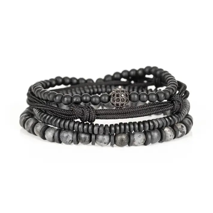 Black and gray layered men’s bracelet set with matte black beads, gray marbled stone accents, braided rope wraps, metallic spacers, and pavé centerpiece on white background.