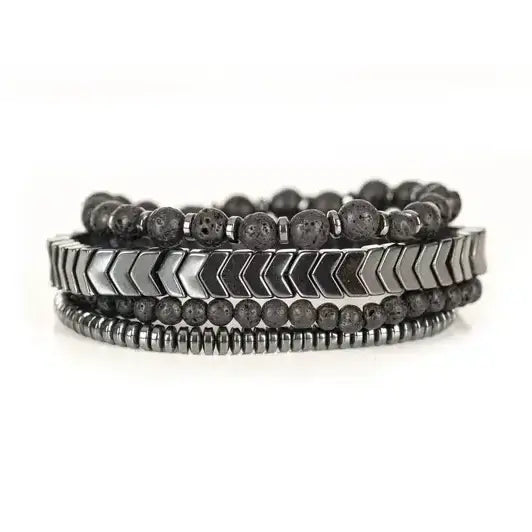 Black multi-layer men’s bracelet featuring lava stone beads, silver chevron metal bar, hematite spacer beads, and layered metallic accents on a light background.