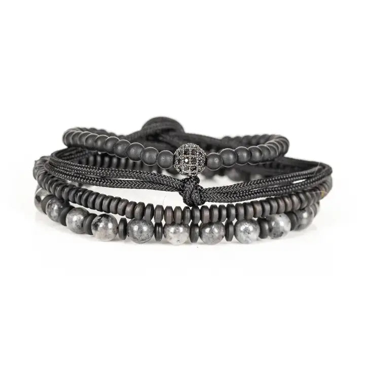 Black and gray layered men’s bracelet set with matte black beads, gray marbled stone accents, braided rope wraps, and pavé centerpiece on white background.