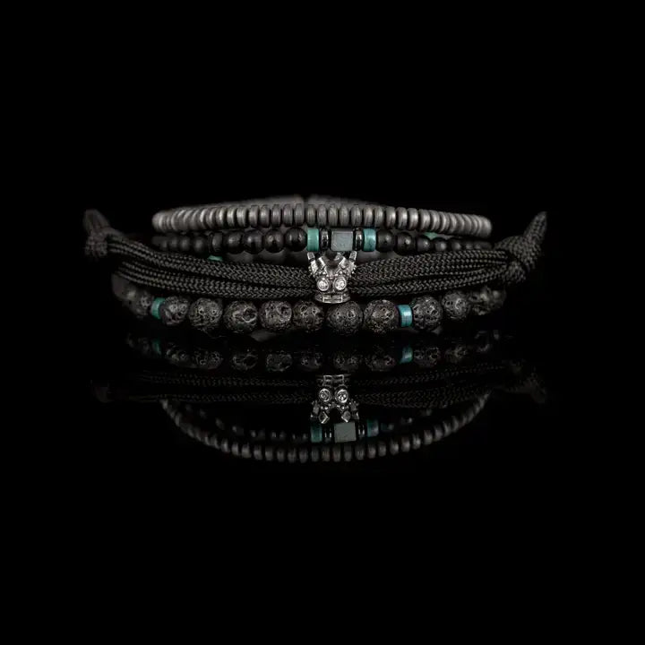 Black layered men’s bracelet set with lava stone beads, braided rope wraps, hematite accents, and turquoise detail on white background.