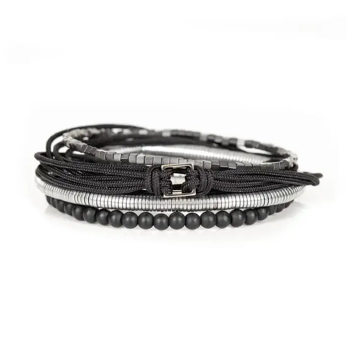 Black and silver layered men’s bracelet set with matte black beads, silver hematite-style spacers, braided rope wraps, and minimalist metallic centerpiece on white background.
