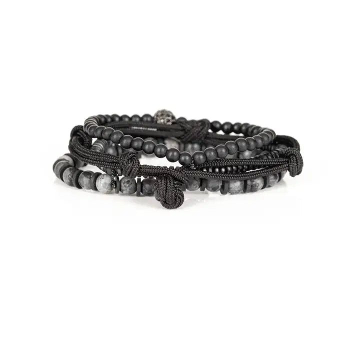 Black and gray layered men’s bracelet set with matte black beads, gray marbled stone accents, braided rope wraps, metallic spacers, and pavé centerpiece on white background.