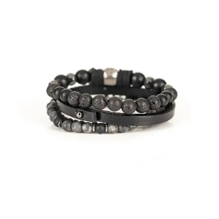 Black multi-layer men’s bracelet set featuring faceted black onyx beads, lava stone accents, black leather band, and silver skull centerpiece on a light background.