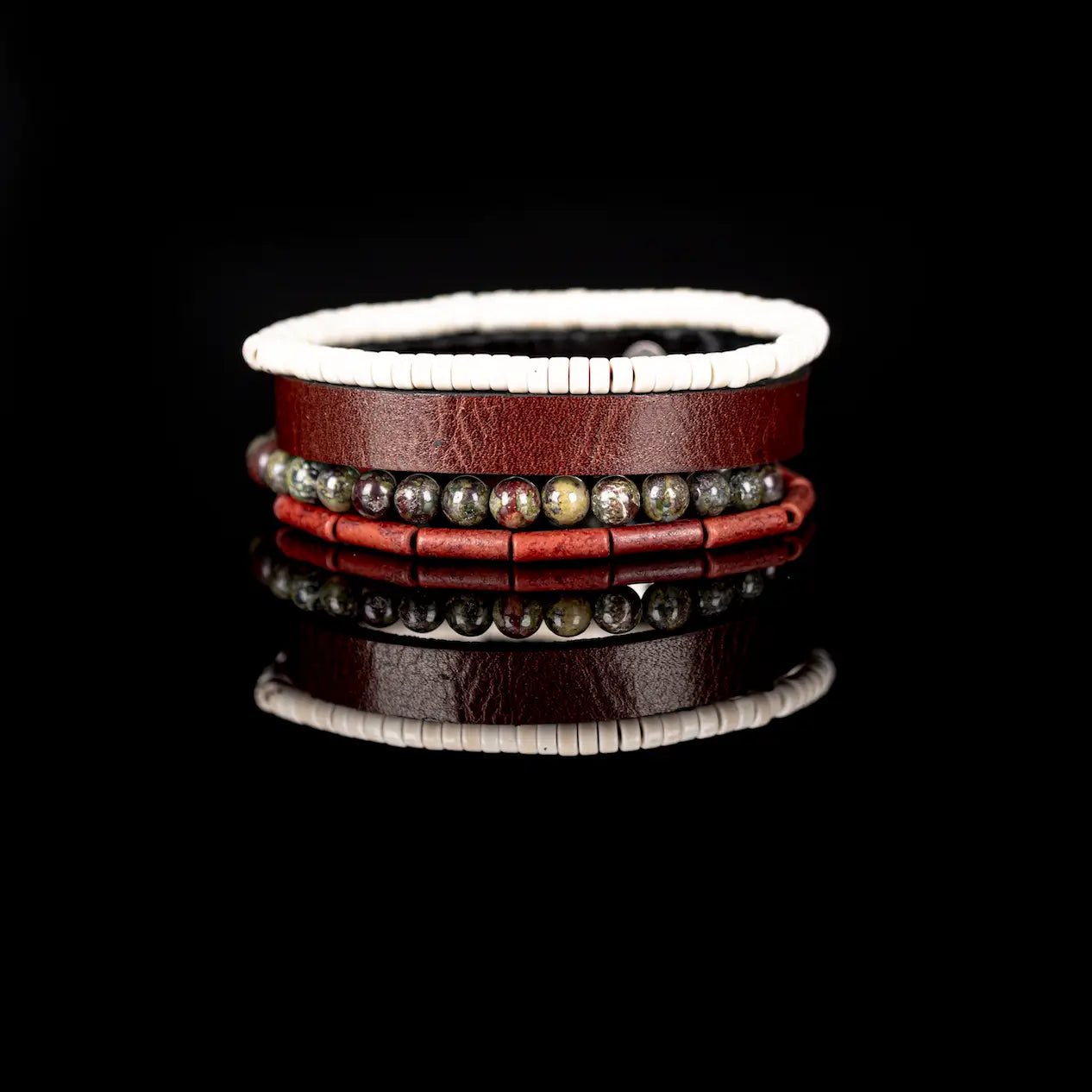 Men’s layered bracelet set featuring a brown genuine leather cuff, white howlite heishi beads, green and burgundy dragon blood jasper beads, and red cylindrical stone beads, stacked in a rugged earthy luxury design on a white background.