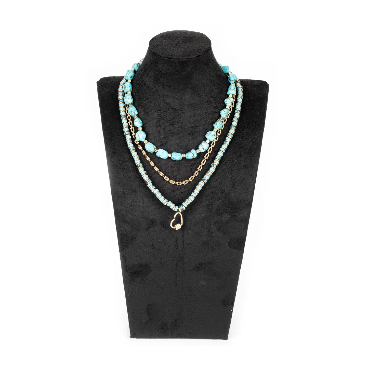 Layered turquoise bead necklace with gold chain and small heart charm on white background.
