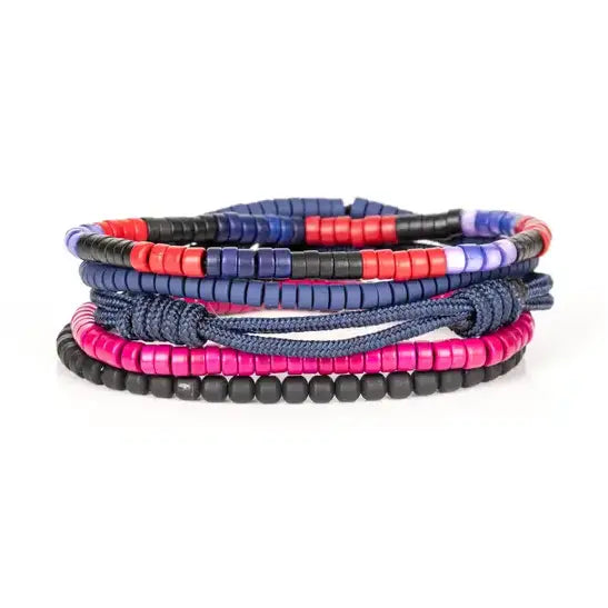 Men’s layered bracelet set featuring navy blue braided cord, blue, black, red, and fuchsia heishi beads, black cube beads, and marbled blue accent beads, stacked in a vibrant contemporary luxury design on a white background.