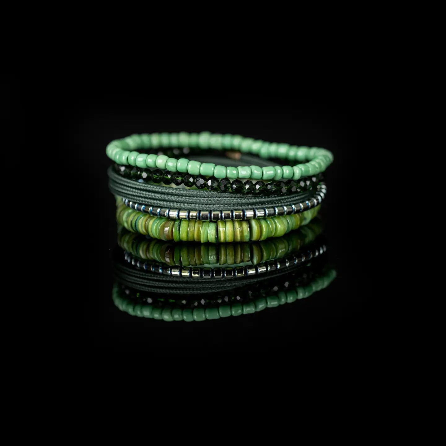 Men’s layered bracelet set featuring mint green seed beads, faceted dark green crystal beads, olive braided cord wraps, silver-tone hematite spacer beads, and green natural shell heishi beads, stacked in a fresh nature-inspired luxury design on a white background.
